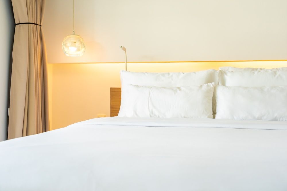 Oreiller et couverture blancs sur le lit